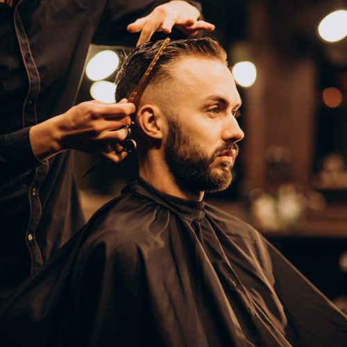 Young man at barbershop trimming hair